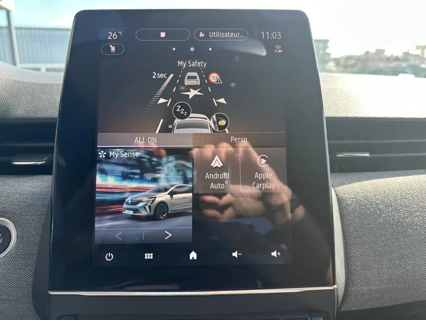 Écran tactile central affichant les aides à la conduite et connectivité Android Auto/Apple Carplay dans Renault Clio rouge Flamme 2025.