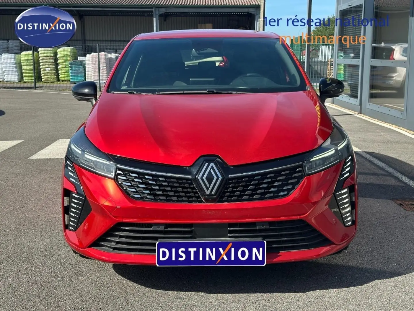 Vue frontale d'une Renault Clio 1.0 Eco-G 100ch Techno rouge flamme avec calandre noire et feux LED distinctifs.