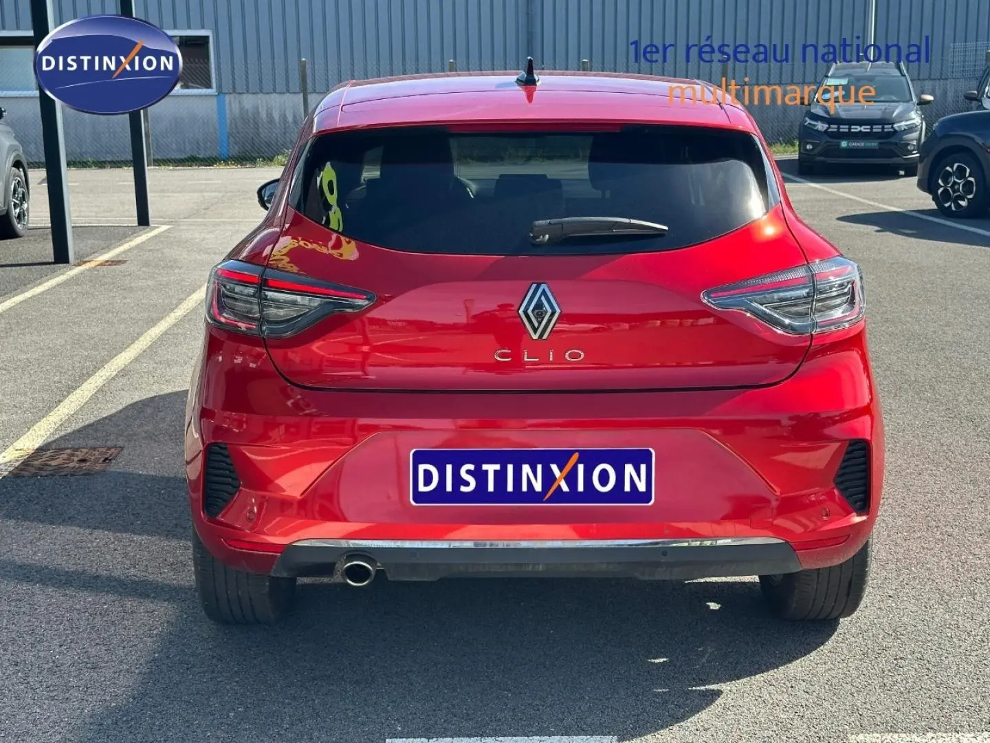 Vue arrière d'une Renault Clio rouge Flamme 2025 avec feux LED et sortie d'échappement chromée visible.