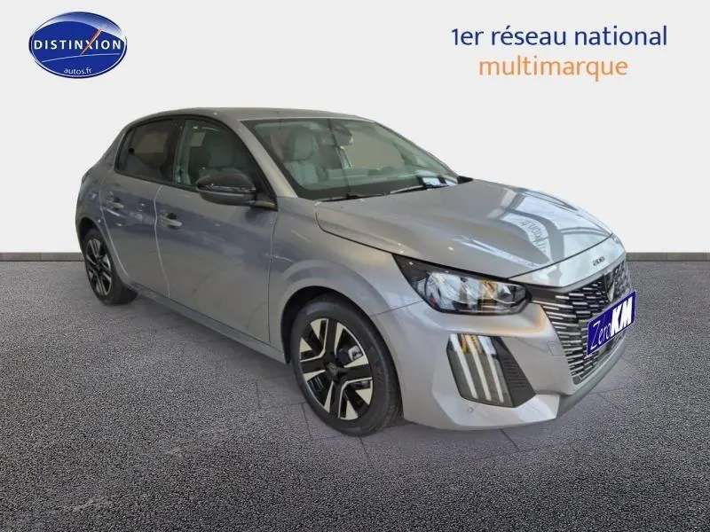 Peugeot 208 gris Artense vue 3/4 avant droit, avec calandre distinctive et jantes alliage modernes.