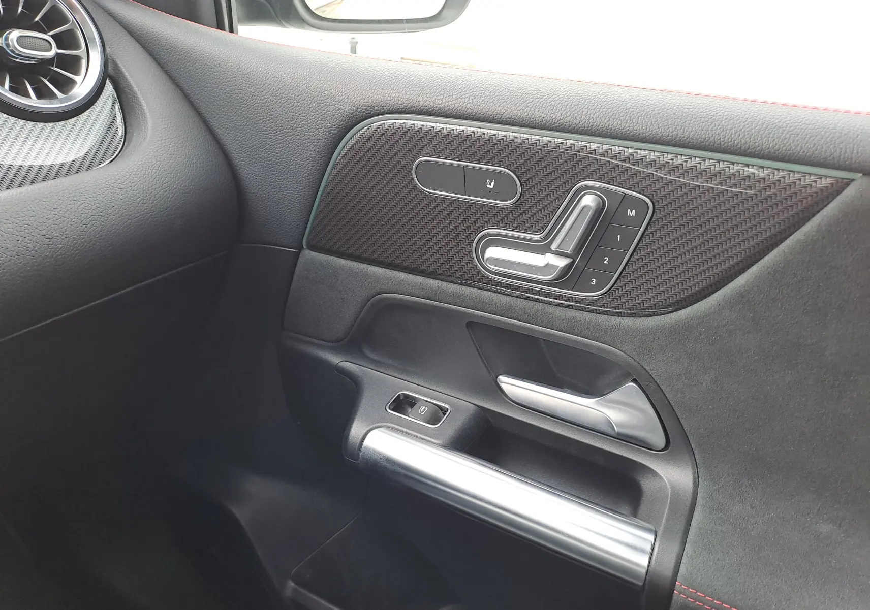 Détail de la porte côté droit d'une Mercedes Classe B AMG Line 2019, avec commandes de siège et finition noire élégante.