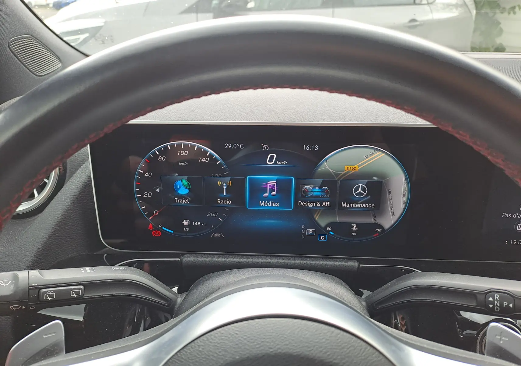 Vue depuis le poste de conduite d'une Mercedes Classe B 1.3i AMG Line 2019, affichage numérique du tableau de bord.