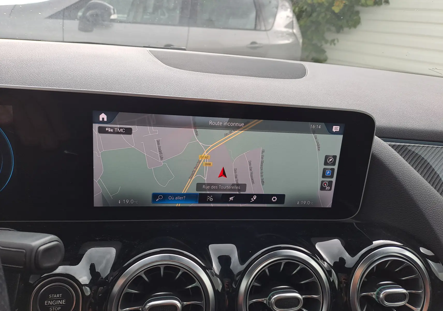 Vue intérieure du tableau de bord de la Mercedes Classe B AMG Line 2019, écran GPS et aérateurs ronds noirs brillants.