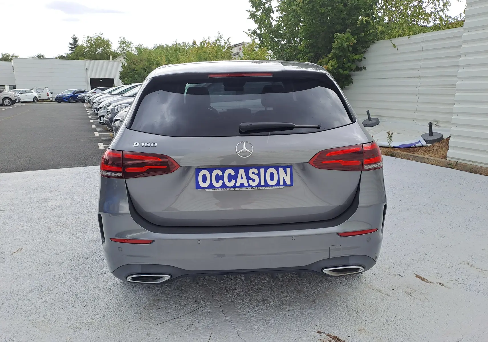 Vue arrière d'une Mercedes Classe B 180 gris foncé métallisé avec feux LED et double sortie d'échappement chromée.