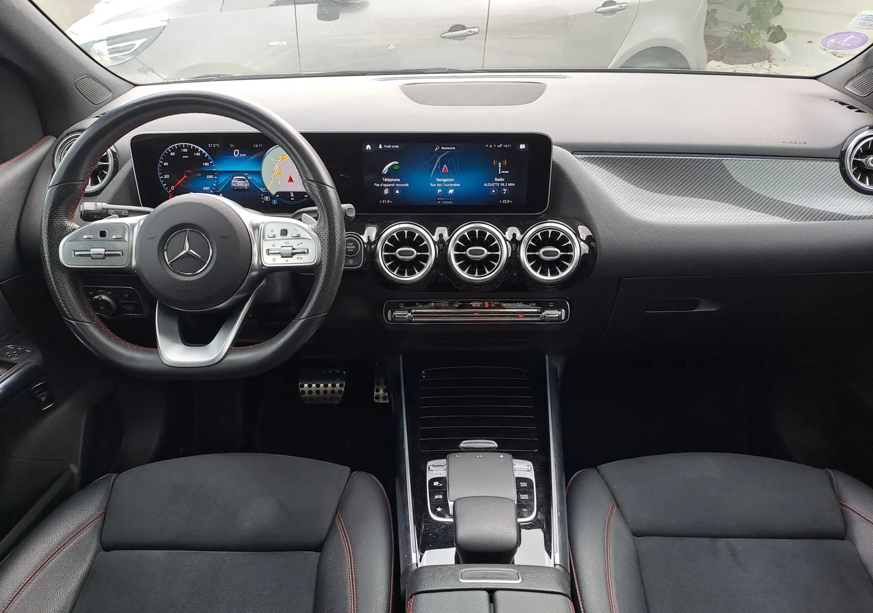 Vue intérieure avant de la Mercedes Classe B AMG Line 2019 avec tableau de bord numérique et volant multifonction noir.