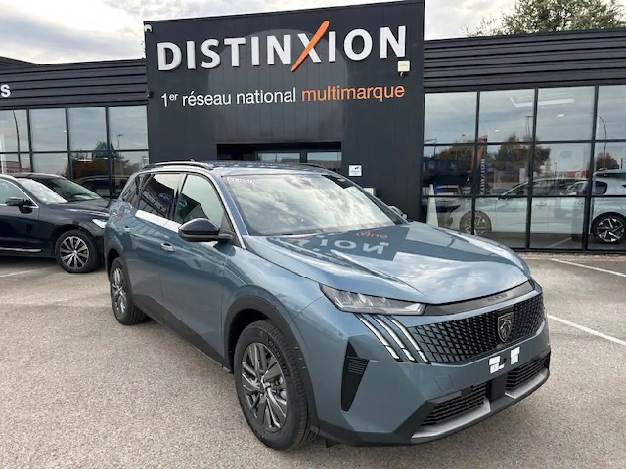 Peugeot 5008 hybride bleu Ingaro en 3/4 avant droit avec calandre noire et feux LED griffés visibles