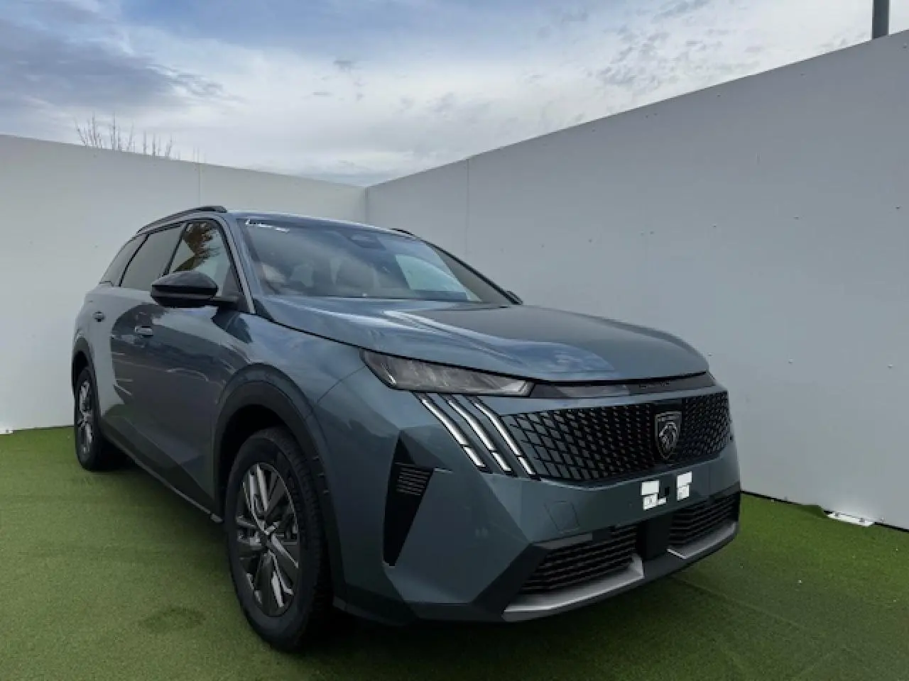 Peugeot 5008 bleu Ingaro en 3/4 avant droit, avec calandre noire et feux LED griffés distinctifs.