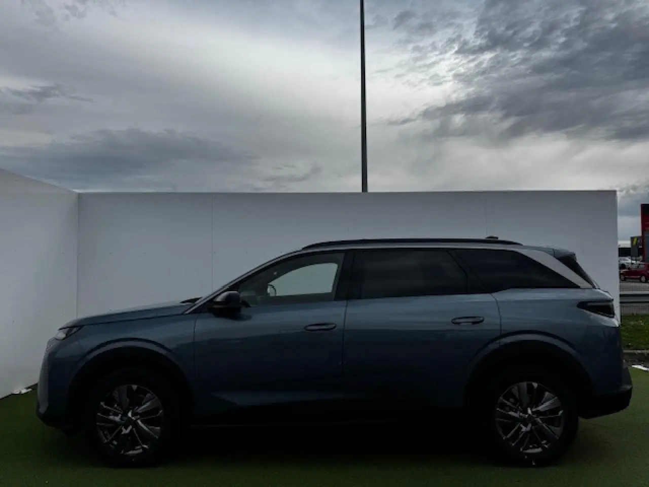 Profil côté gauche du Peugeot 5008 bleu Ingaro métallisé, avec jantes alliage et vitres arrière teintées.