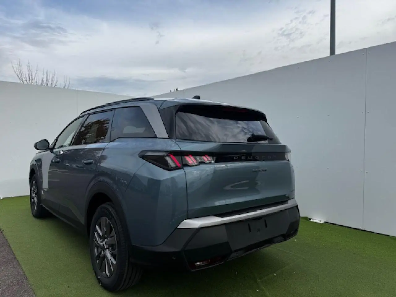 Peugeot 5008 bleu Ingaro métal vue 3/4 arrière droit, feux arrière LED à trois griffes et vitres surteintées.