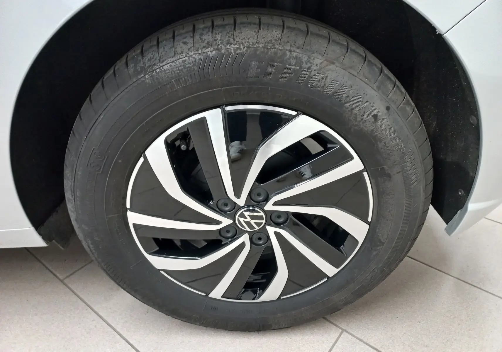 Gros plan sur la roue avant gauche argentée d'une Volkswagen Polo 2024 avec jante noire et argentée au design moderne.