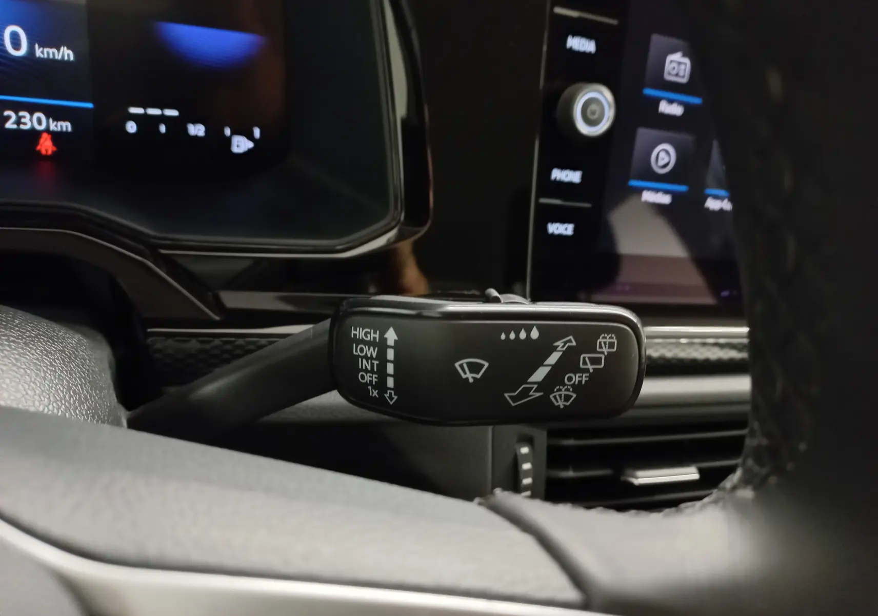 Gros plan sur la commande des essuie-glaces dans l'habitacle d'une Volkswagen Polo argent 2024, tableau de bord en arrière-plan.