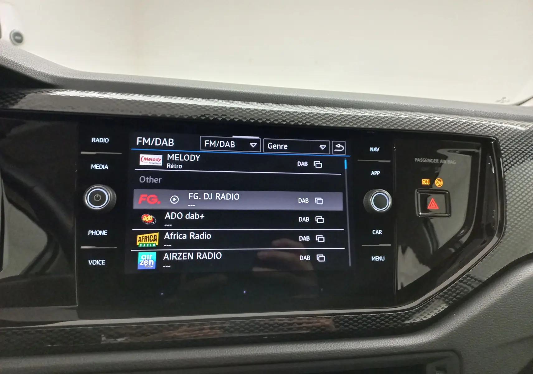 Écran tactile central de la Volkswagen Polo 2024 en finition Life, affichant les stations FM/DAB avec interface noire et boutons tactiles.