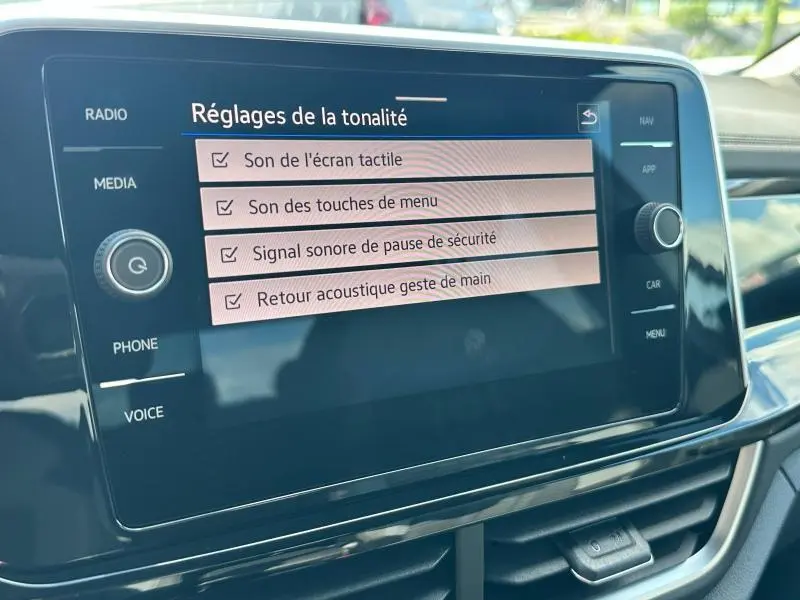 Écran tactile central du Volkswagen T-Roc 2025 affichant les réglages sonores dans un intérieur noir brillant.