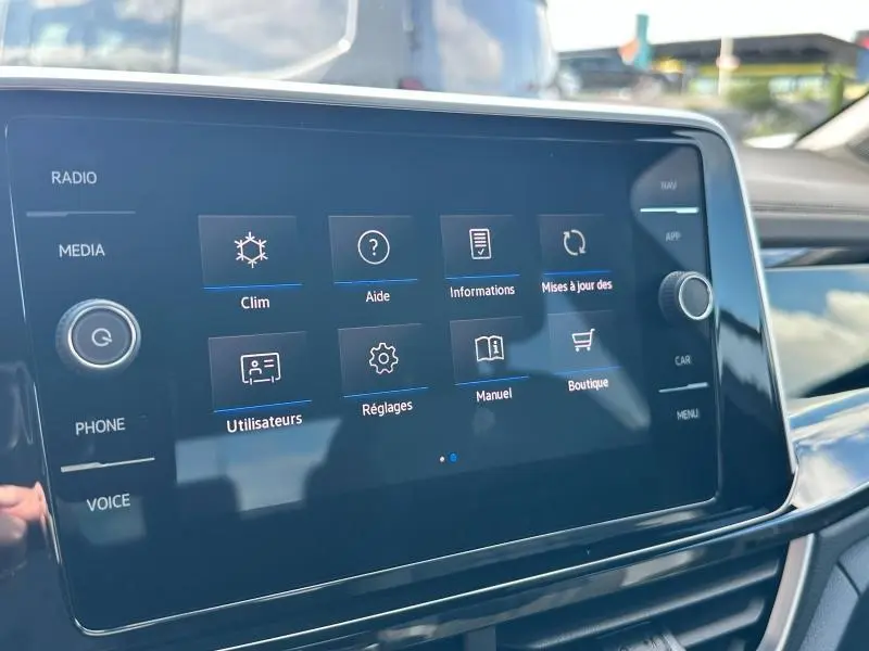 Écran tactile central du Volkswagen T-Roc 2025 affichant le menu principal avec options climatisation et réglages.