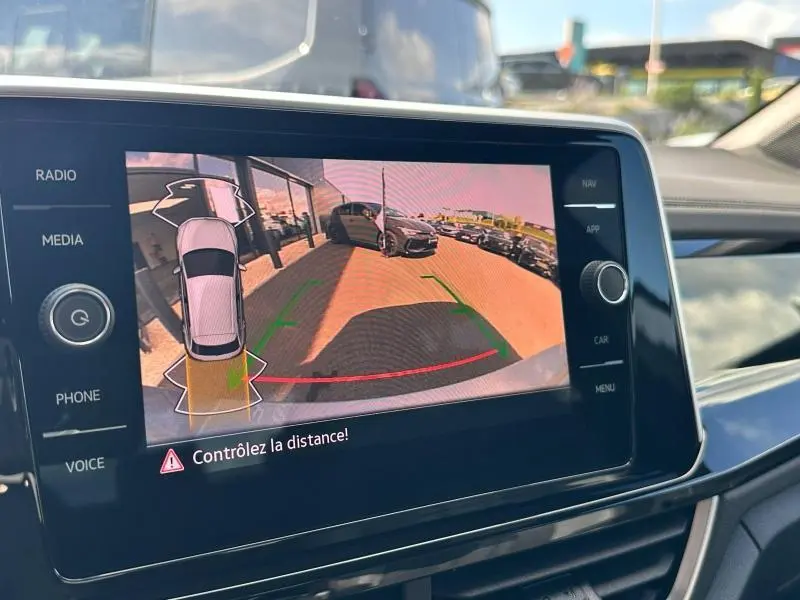 Vue de l'écran tactile intérieur montrant la caméra de recul du Volkswagen T-Roc 2025 avec guidage de trajectoire coloré.