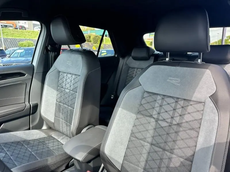 Vue intérieure côté avant droit du Volkswagen T-Roc 2025, sièges en artvelours gris silex avec surpiqûres et logo R.
