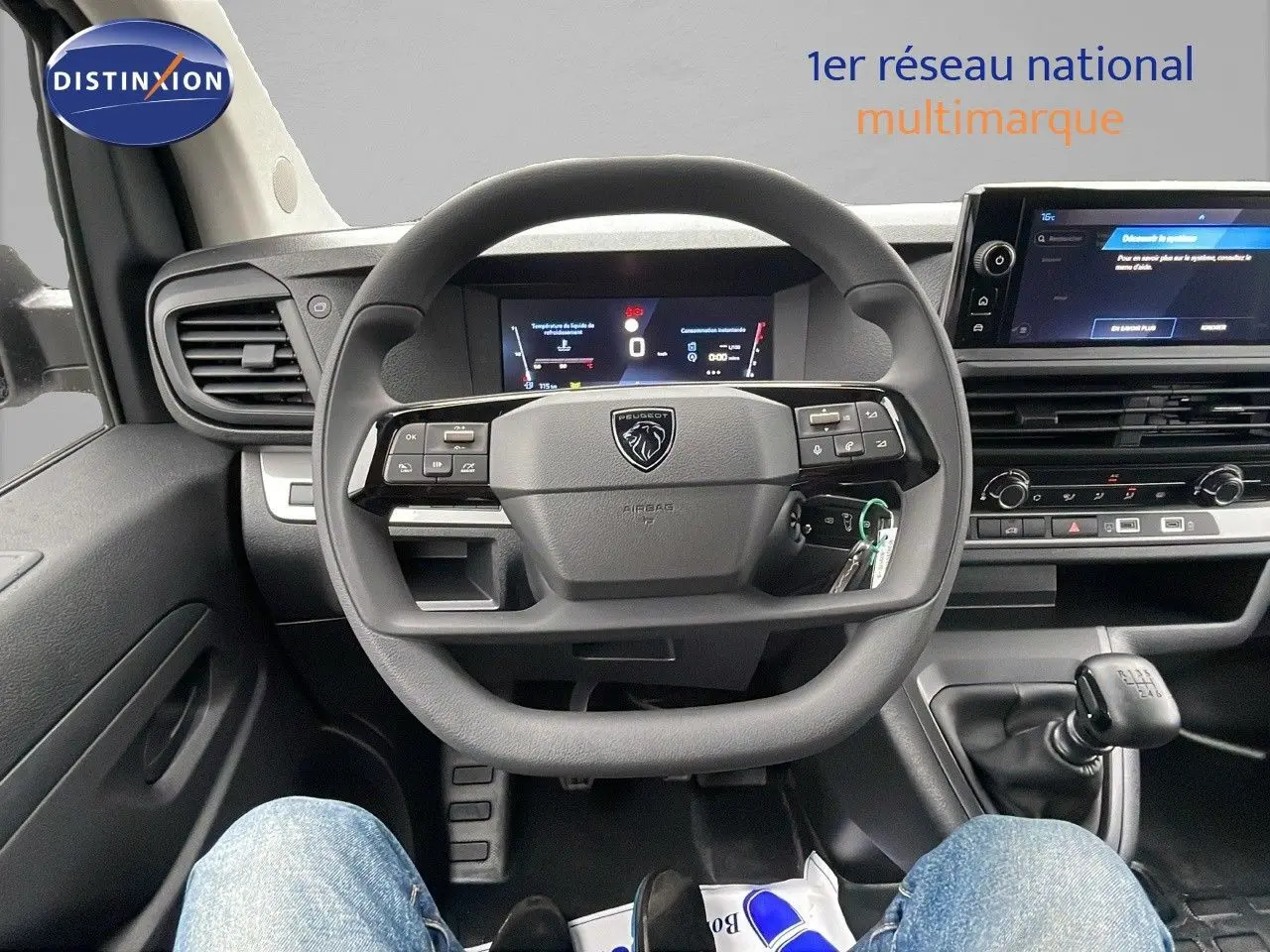 Vue intérieure centrée sur le volant multifonction et la console avec levier de vitesses manuelle du Peugeot Expert Fourgon blanc.