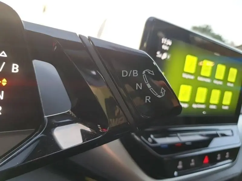 Gros plan sur la commande de boîte automatique D/B du Volkswagen ID.4 2023, avec écran tactile et tableau de bord en arrière-plan.