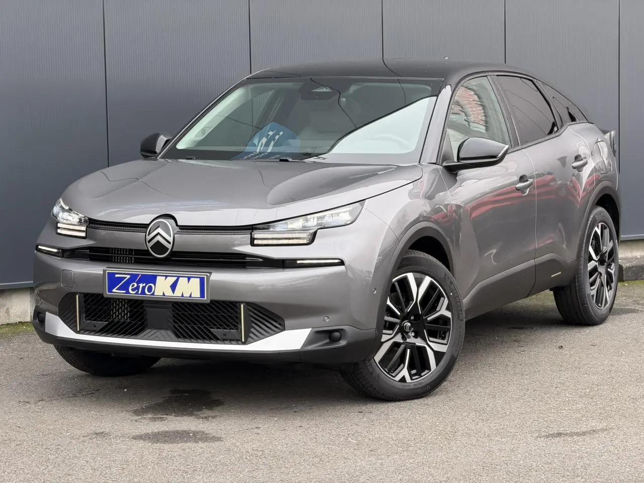 Citroën C4 NV Hybrid 145 gris Mercury en 3/4 avant droit avec toit bi-ton noir et jantes alliage 18 pouces.