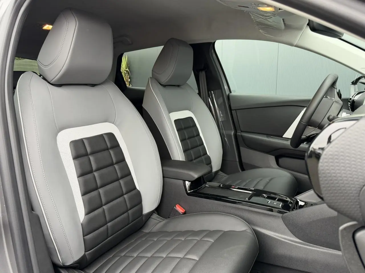 Vue intérieure de profil droit sur les sièges Advanced Comfort gris clair et noir de la Citroën C4 NV Hybrid 2025.