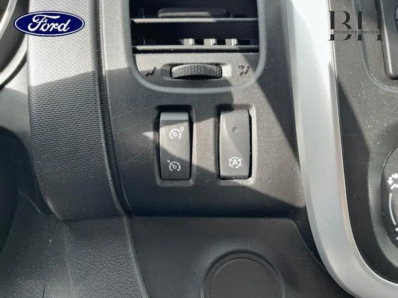 Gros plan sur les commandes du régulateur de vitesse et arrêt/redémarrage auto dans un Renault Trafic blanc glacier.