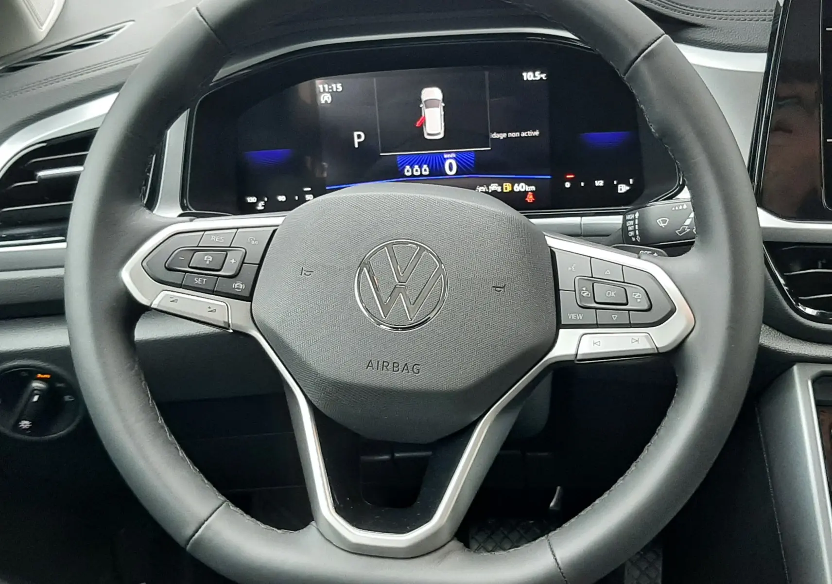 Vue rapprochée du volant noir du Volkswagen T-Roc 2025 avec tableau de bord numérique et commandes intégrées.