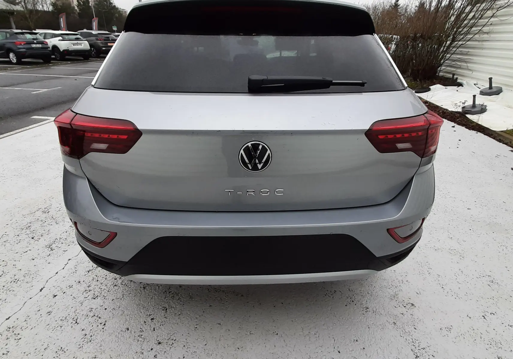 Vue arrière d'un Volkswagen T-Roc gris pyrite métal 2025 avec feux LED et lunette arrière teintée.