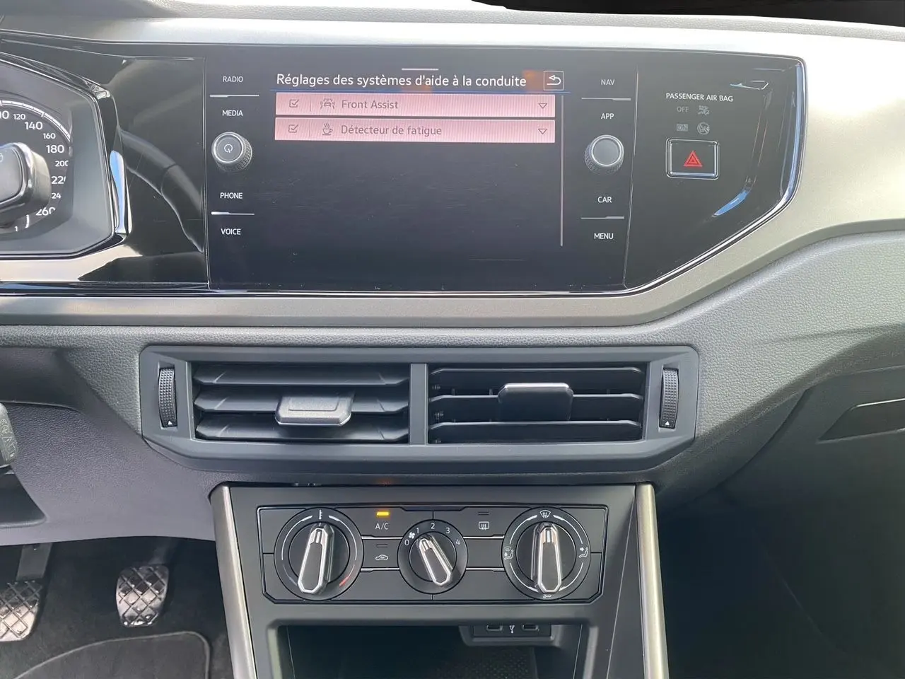 Tableau de bord intérieur noir de Volkswagen Polo 2020, avec écran tactile affichant les aides à la conduite.