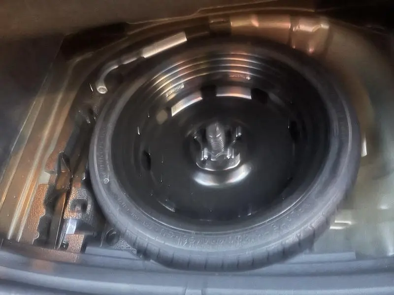 Vue plongeante sur la roue de secours noire dans le coffre du SEAT Ateca 2022 Noir Magique Métal.