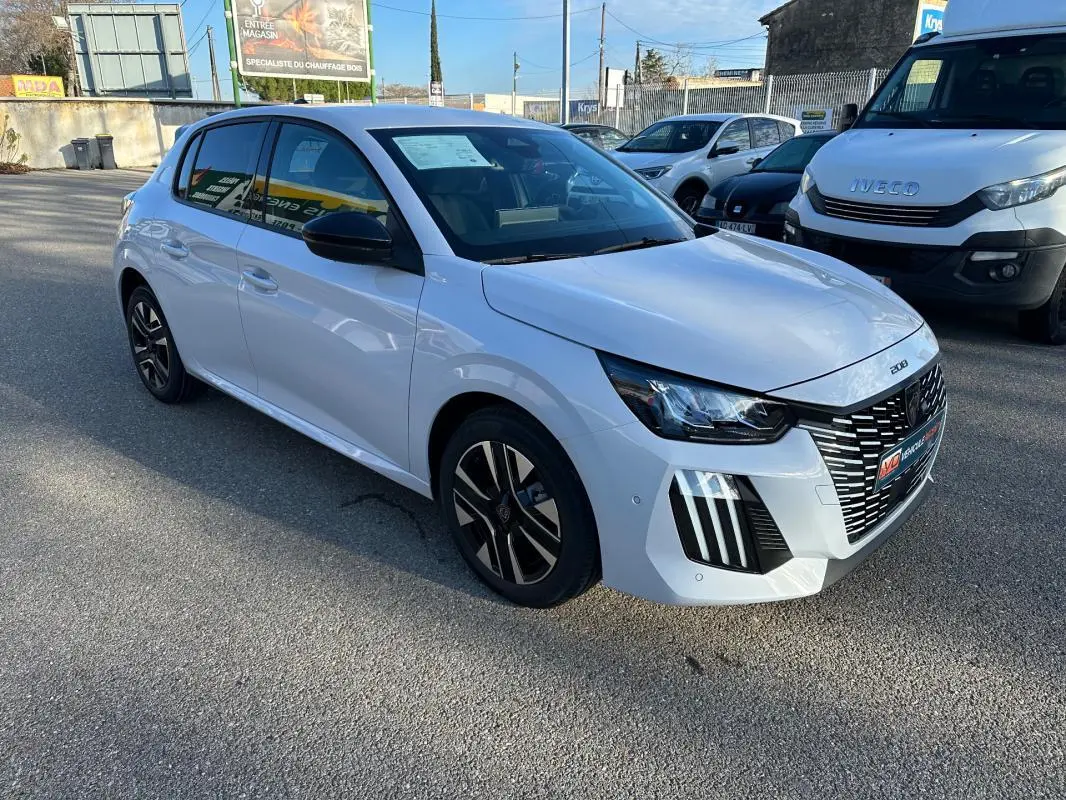 Peugeot 208 Hybrid blanc vue 3/4 avant droit, jantes alliage 16 pouces et calandre distinctive.