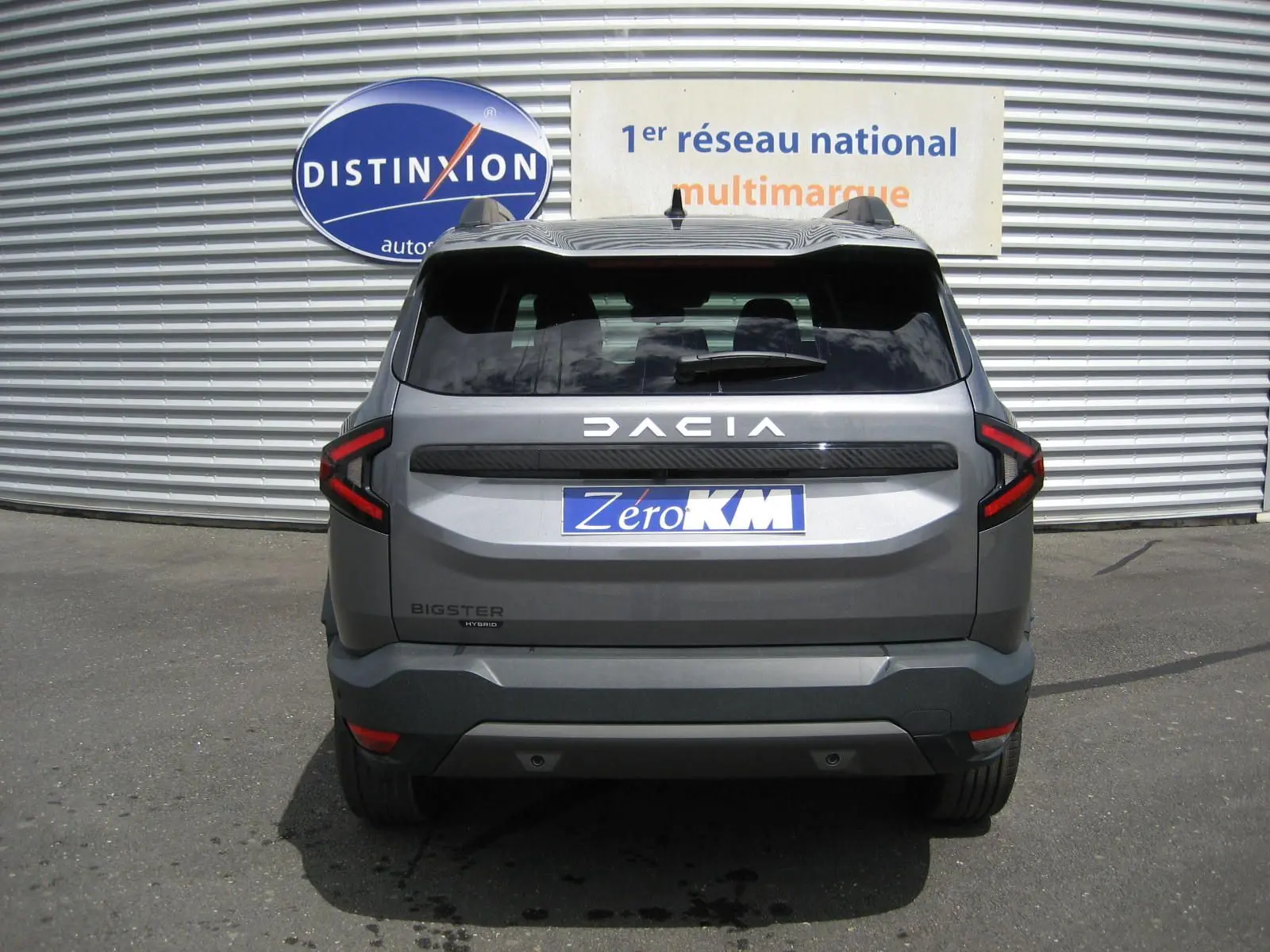 Vue arrière d'un Dacia Bigster gris schiste 2026 avec feux LED en forme de C et logo distinctif bien visible.