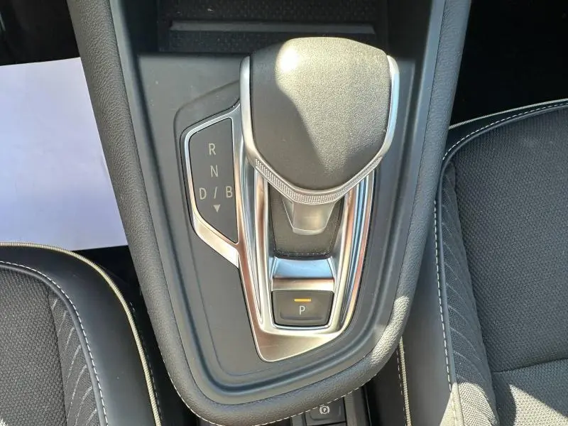 Vue rapprochée du levier de vitesses automatique gris et chrome dans l'habitacle du Renault Symbioz rouge.