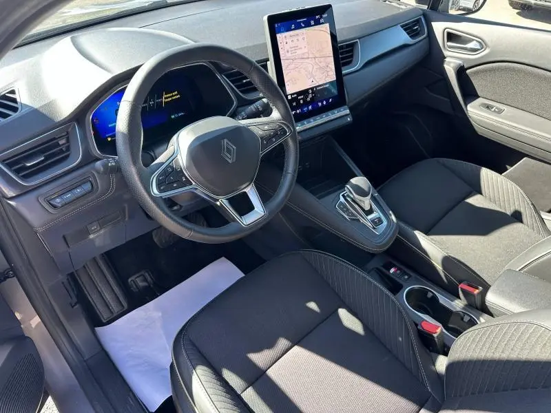Vue intérieure côté conducteur du Renault SYMBIOZ 2025, volant multifonction et grand écran tactile vertical noir.