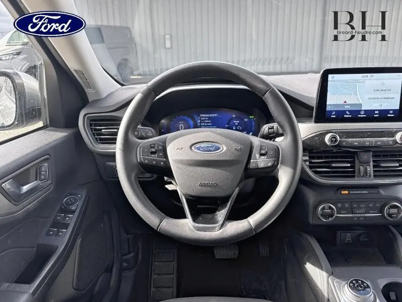 Vue intérieure centrée sur le volant cuir multifonction du Ford Kuga 2022 avec écran tactile et tableau de bord numérique.