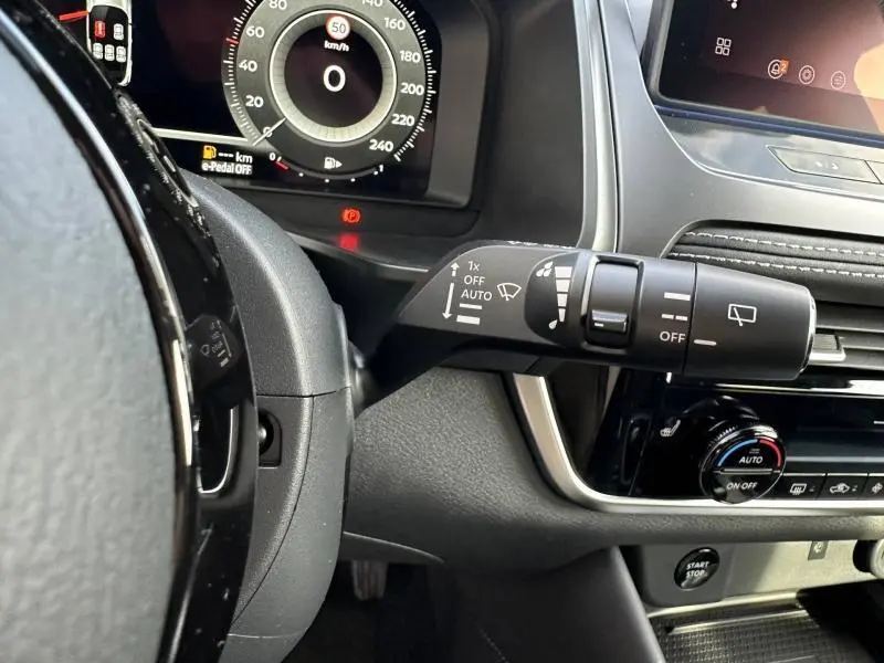 Détail intérieur du Nissan Qashqai Hybrid e-POWER 2025 montrant la commande d’essuie-glace côté droit et le tableau de bord numérique.
