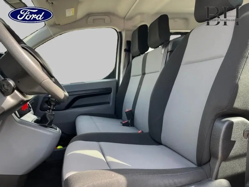 Vue intérieure côté conducteur du Peugeot Expert Fourgon 2017, sièges tissu Curitiba gris et noir, volant et levier de vitesse visibles.