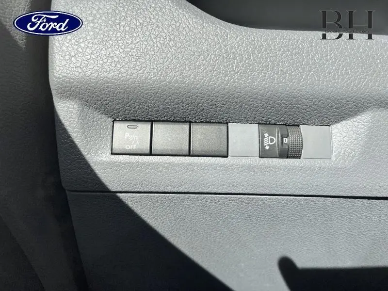 Détail des commandes de réglage des phares et désactivation du radar de stationnement sur tableau de bord gris d'un Peugeot Expert Fourgon blanc.