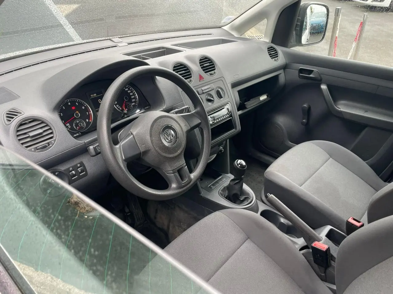 Vue intérieure côté conducteur du Volkswagen Caddy 2014, montrant le tableau de bord et la boîte manuelle.