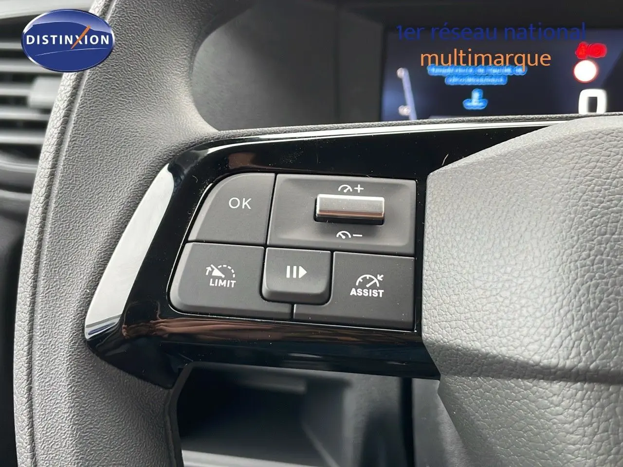 Gros plan sur les commandes au volant noir du Peugeot Expert Fourgon blanc, version 2025, côté gauche.