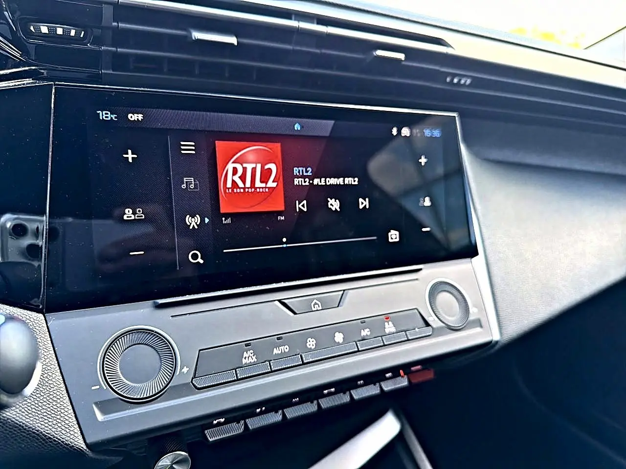 Vue rapprochée de l'écran tactile central et de la console de la Peugeot 308 gris selenium, affichant la radio RTL2.