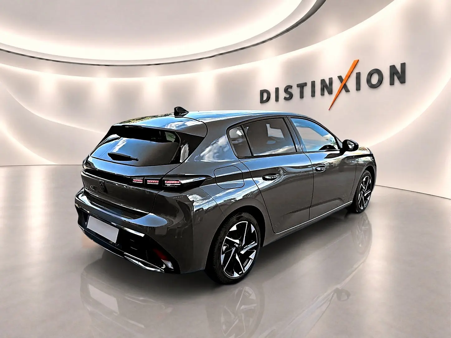 Peugeot 308 gris selenium vue 3/4 arrière droit en intérieur avec jantes alliage et feux LED distinctifs.