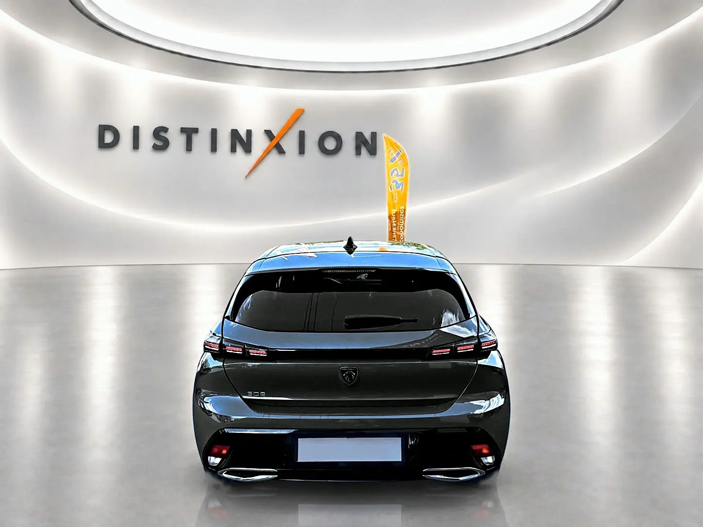 Vue arrière d'une Peugeot 308 gris selenium 2025 avec feux LED et double sortie d'échappement en showroom.