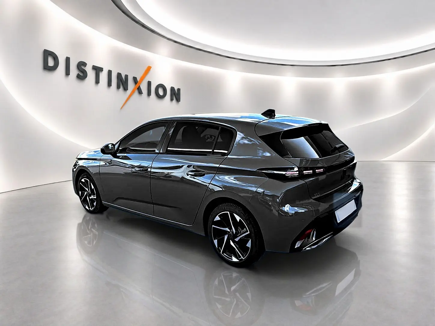 Peugeot 308 gris selenium en 3/4 arrière droit, avec jantes alu noires et feux arrière LED distinctifs.