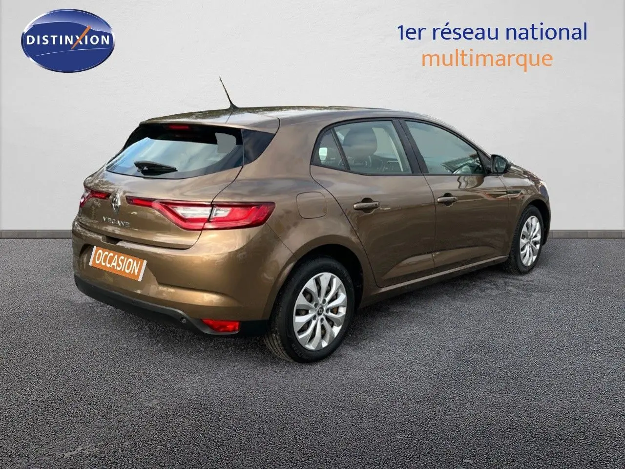 Renault Mégane IV brun capuccino vue 3/4 arrière droit, avec jantes alliage et feux arrière allumés.