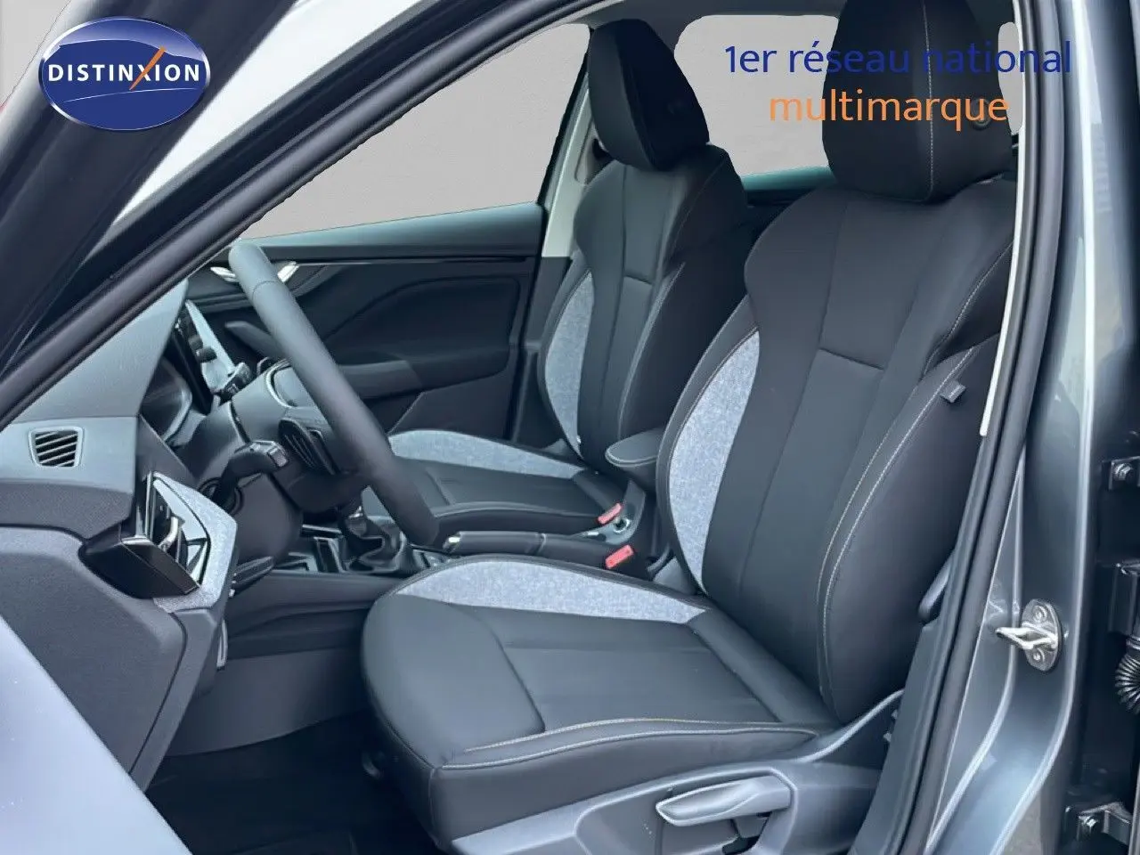 Vue intérieure côté conducteur du Skoda Kamiq gris graphite, mettant en valeur les sièges tissu et cuir bicolores.