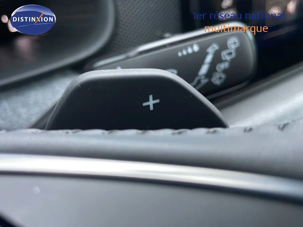Gros plan sur la palette de passage de vitesse "+" du volant dans l'habitacle gris graphite du Skoda Kamiq 2025.