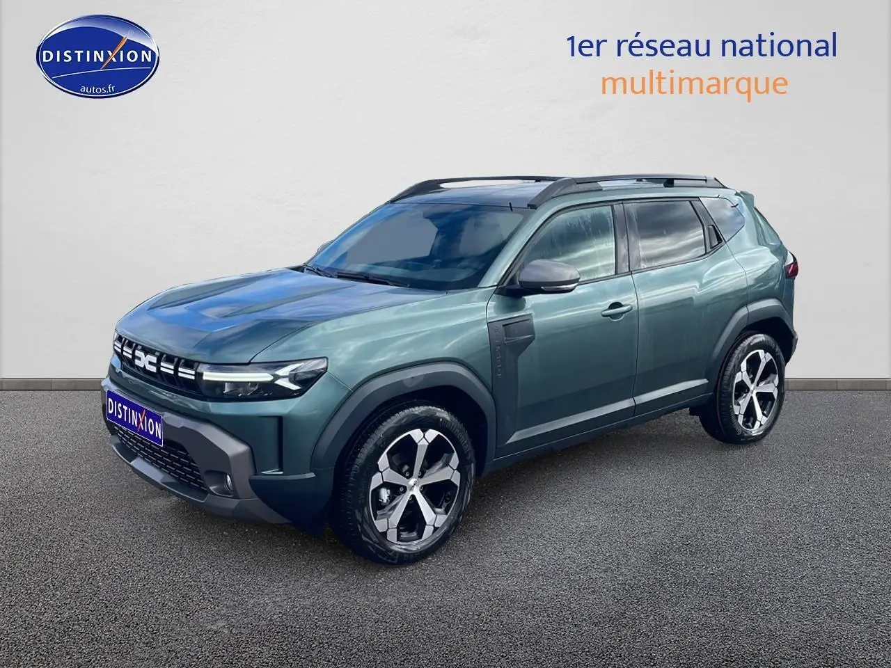 Dacia Duster 1.2 mild hybrid vert cèdre en 3/4 avant droit, avec jantes alliage et barres de toit noires.