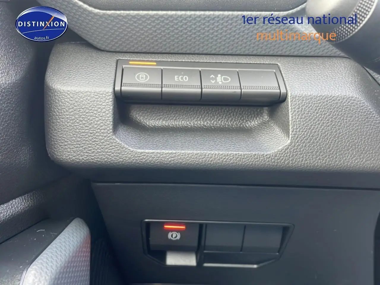 Détail des commandes de tableau de bord noir dans un Dacia Duster 2026 vert cèdre, côté conducteur.