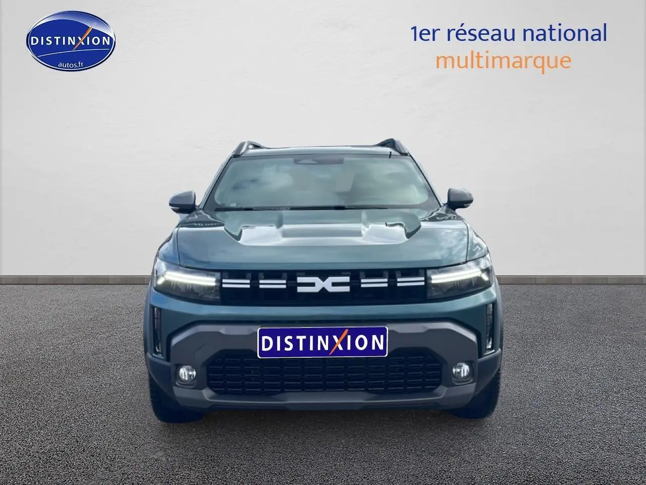 Vue frontale d'un Dacia Duster 1.2 mild hybrid 140 Journey vert cèdre avec calandre noire et phares LED allumés.