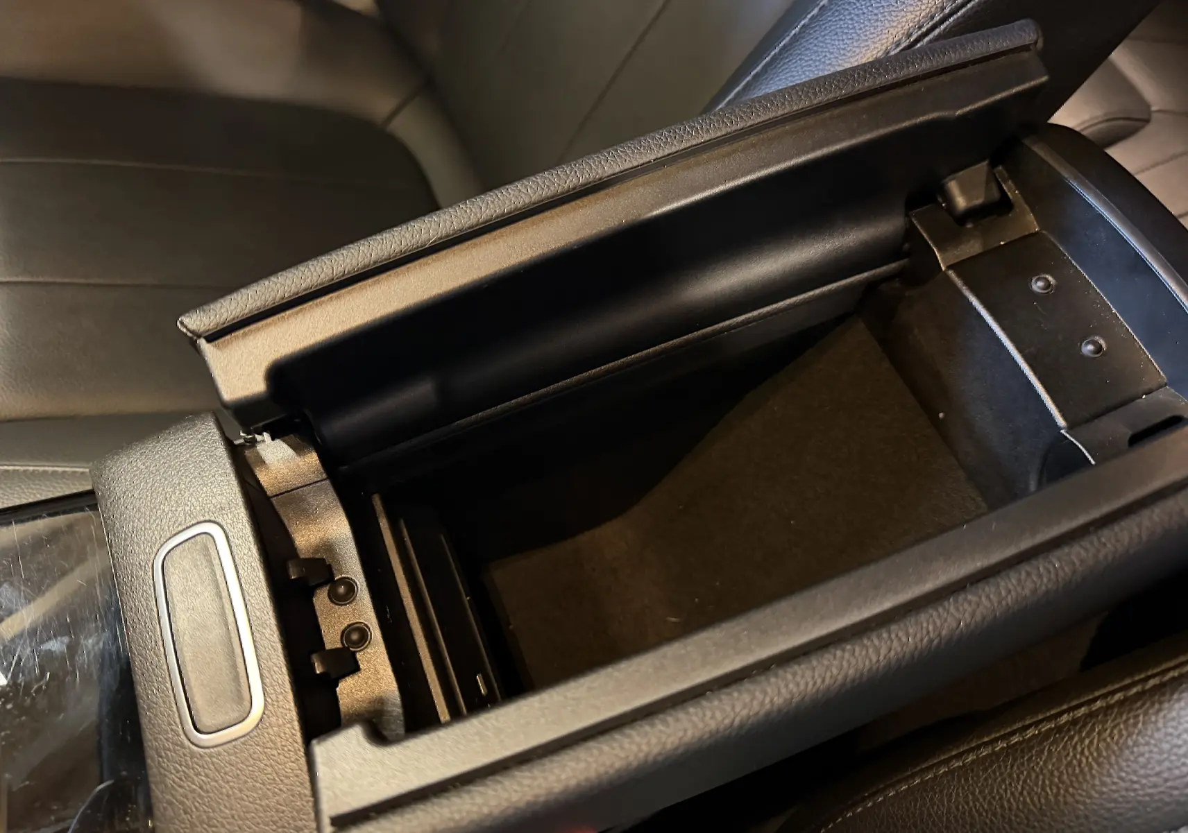 Vue rapprochée de l'accoudoir central avant ouvert en cuir noir dans l'habitacle de la Mercedes Classe A 2022.